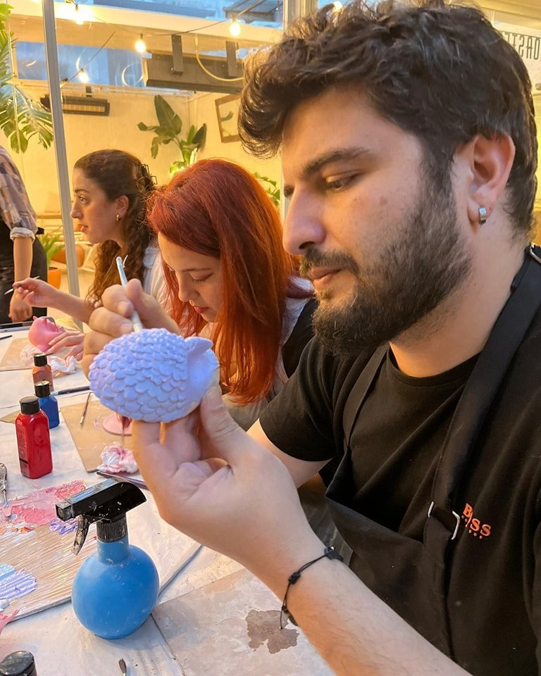 Atölye masasında birlikte eser yapan arkadaşlar